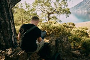 digital-nomad-travaillant-sur-ordinateur-bord-de-mer